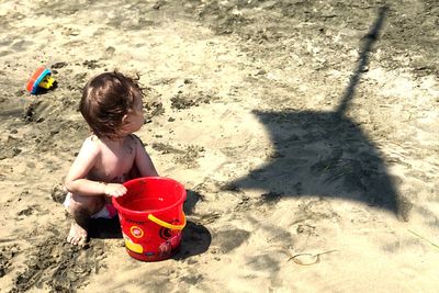 High angle view of girl playing with toy on sand