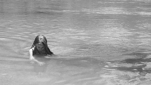 Rear view of woman swimming in pool