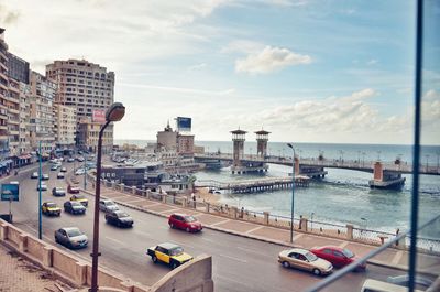 View of city by sea against sky