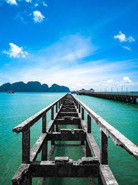 Pier over sea against blue sky