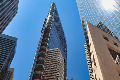 Low angle view of modern buildings against clear blue sky