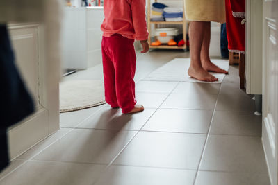 Low section of people standing on tiled floor