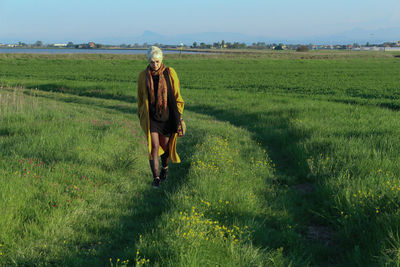 Full length of woman walking on grassy field