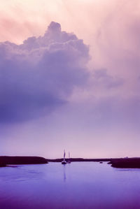 Scenic view of bay against sky at sunset