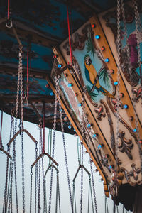 Low angle view of chain swing rides at amusement park