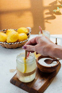 Midsection of man holding ice cream on table