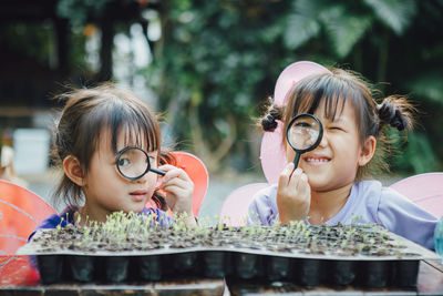 Cute girls looking through magnifying glass