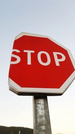 Low angle view of road sign against clear sky