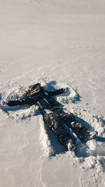 Full length of woman sitting on snowcapped mountain 