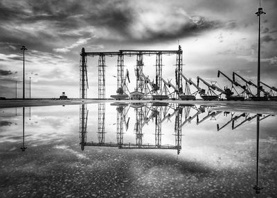 Cranes at commercial dock against sky