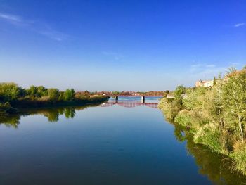 Scenic view of river against blue sky