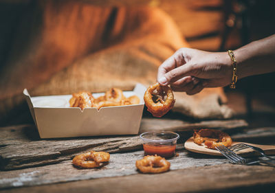 Cropped hand of person preparing food on table