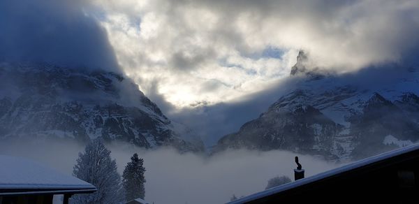 Low angle view of snowcapped mountains against sky
