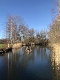 Scenic view of lake against clear blue sky