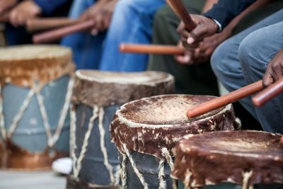 Cropped hands of men playing drum