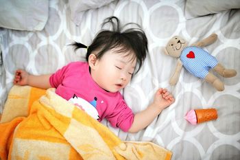 PORTRAIT OF CUTE BABY GIRL LYING ON BED