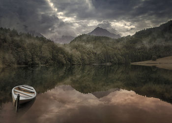 Scenic view of lake by mountains against sky