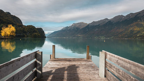 Pier over lake against sky in autumn