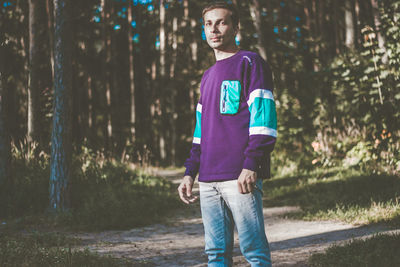 Portrait of young man standing in forest