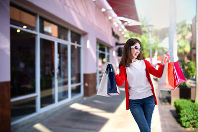 Woman with umbrella standing in front of building