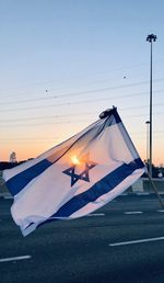 Low angle view of flag against sky during sunset