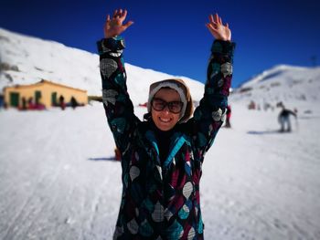 Portrait of smiling young woman standing in snow