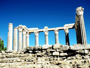 Low angle view of old ruins against clear blue sky