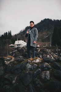 Portrait of young man standing on rock