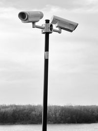 Low angle view of security camera against sky