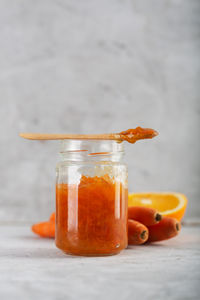 Close-up of orange juice in glass jar on table