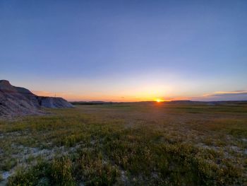 Scenic view of field against sky during sunset