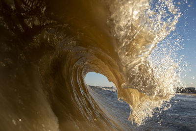 Waves splashing in sea against clear sky