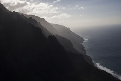 Scenic view of sea and mountains against sky