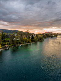 Scenic view of river against sky at sunset