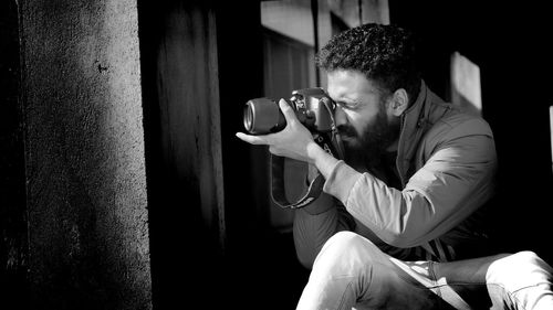 Young man photographing with camera