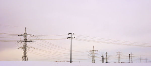 Low angle view of electricity pylon against clear sky