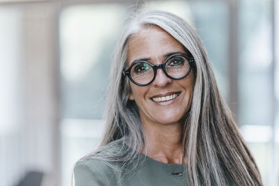 Portrait of smiling woman with long grey hair