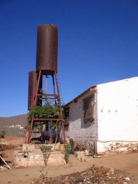 Low angle view of abandoned building against clear blue sky