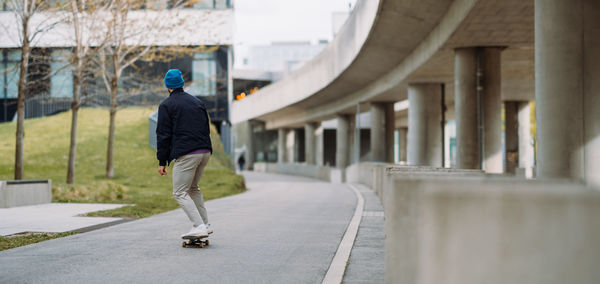 Portrait of active skater boy balancing on skateboard on urban background. banner copy space.