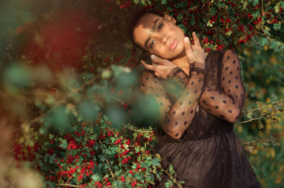 Portrait of a smiling young woman holding flowering plants