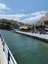 River by buildings in city against sky