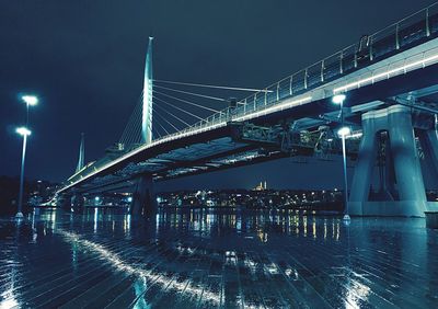 Illuminated bridge over river at night