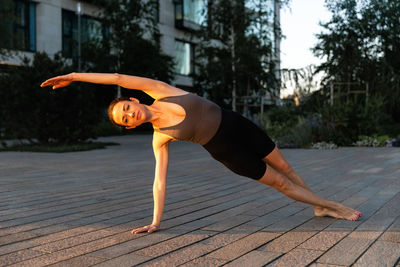 Full length of woman exercising on boardwalk