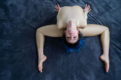 High angle view of young ballet dancer stretching