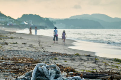 People on beach against sky