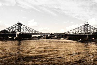 Low angle view of bridge over river against sky