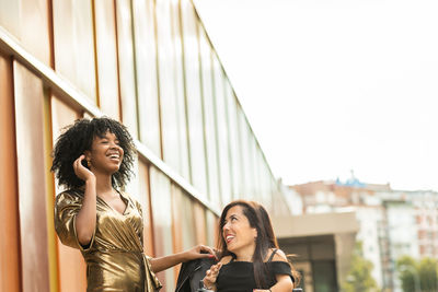 Cheerful female friends sitting outdoors