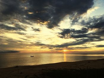 Scenic view of sea against cloudy sky during sunset