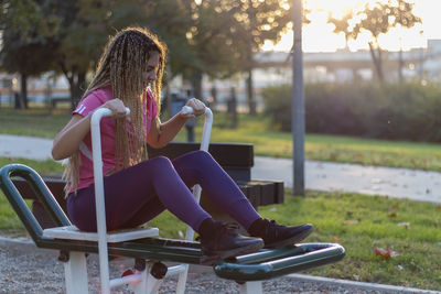 Teen girl using equipment outdoor in the communication with the workout, healthy lifestyle