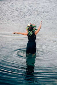 Rear view of woman standing in sea